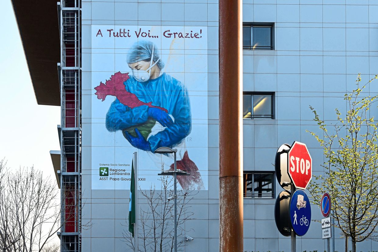 A mural by Venice-born artist Franco Rivolli pays tribute to the heroic hospital staff in his country. It depicts a nurse wearing a face mask, with wings behind her back and cradling Italy. It can be found on a wall of the Papa Giovanni XXIII Hospital in Bergamo, Lombardy in Italy. Photo: AFP Image