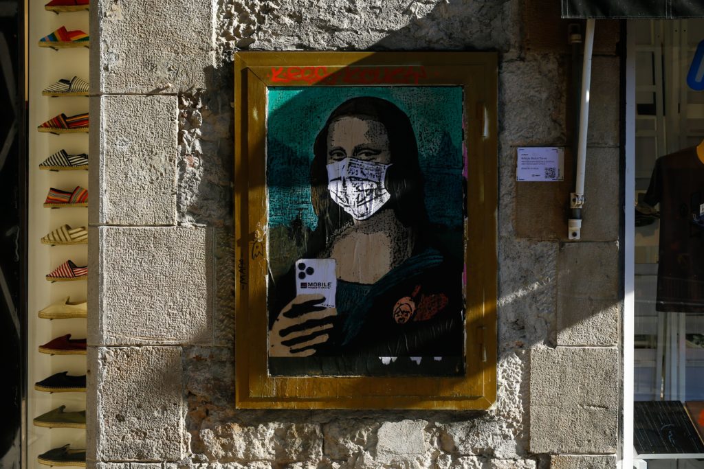 A coronavirus street art poster by Italian urban artist Salvatore Benintende aka “TVBOY” depecting Leonardo da Vinci’s Mona Lisa wearing a protective facemask in Barcelona. Photo by Pau Barrena/AFP via Getty Images. Image