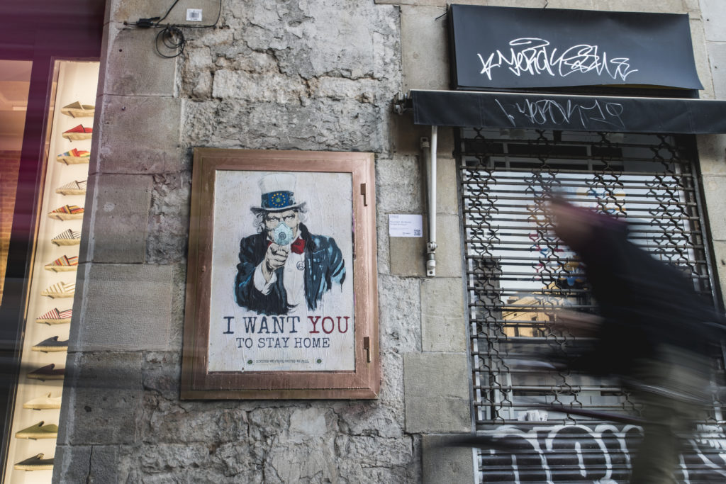 A man rides next to the painting ‘I Want You To Stay Home’ by artist TV Boy in Barcelona, Spain. Photo by Xavi Torrent/Getty Images Image