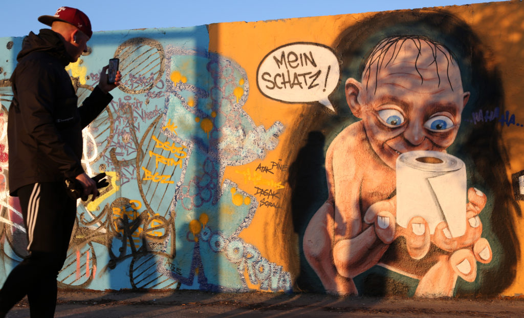 Street art in Berlin featuring the Lord of the Rings character Gollum holding a roll of toilet paper, a shopping item hoarded by consumers during the coronavirus pandemic crisis. Photo by Adam Berry/Getty Images. Image